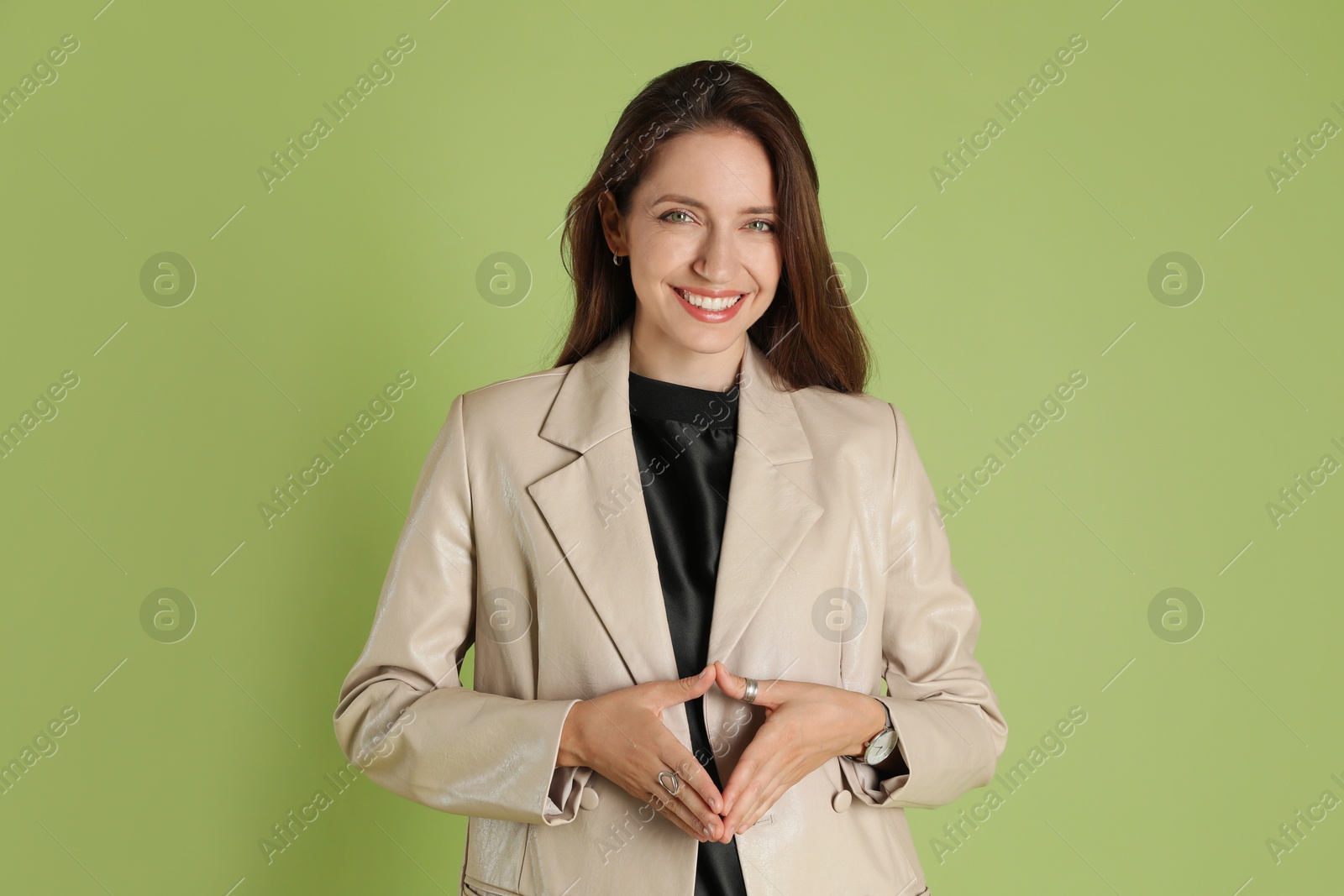 Photo of Beautiful woman in stylish beige jacket on olive background