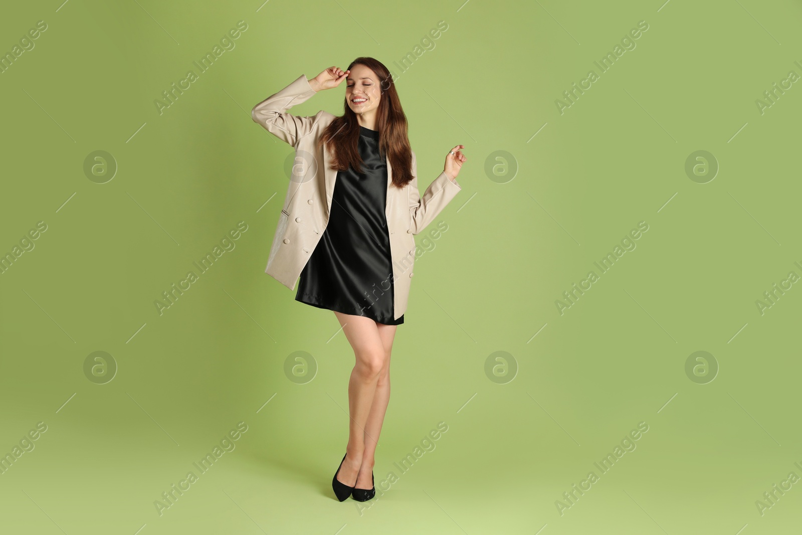 Photo of Beautiful woman in stylish beige jacket on olive background