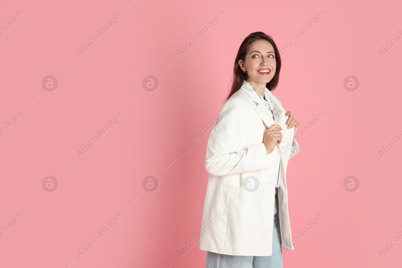 Photo of Beautiful woman in stylish white jacket on pink background, space for text