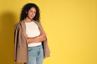 Photo of Beautiful woman with stylish jacket on yellow background, space for text