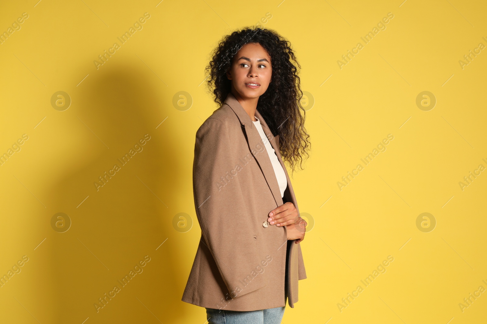 Photo of Beautiful woman with stylish jacket on yellow background