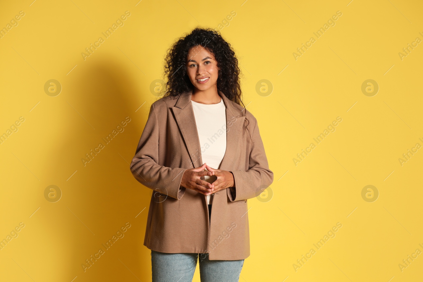 Photo of Beautiful woman in stylish jacket on yellow background