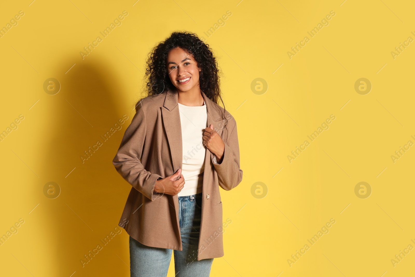 Photo of Beautiful woman in stylish jacket on yellow background