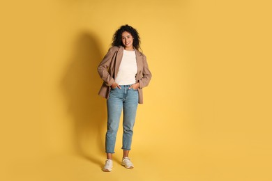 Photo of Beautiful woman in stylish jacket on yellow background