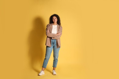 Photo of Beautiful woman in stylish jacket on yellow background