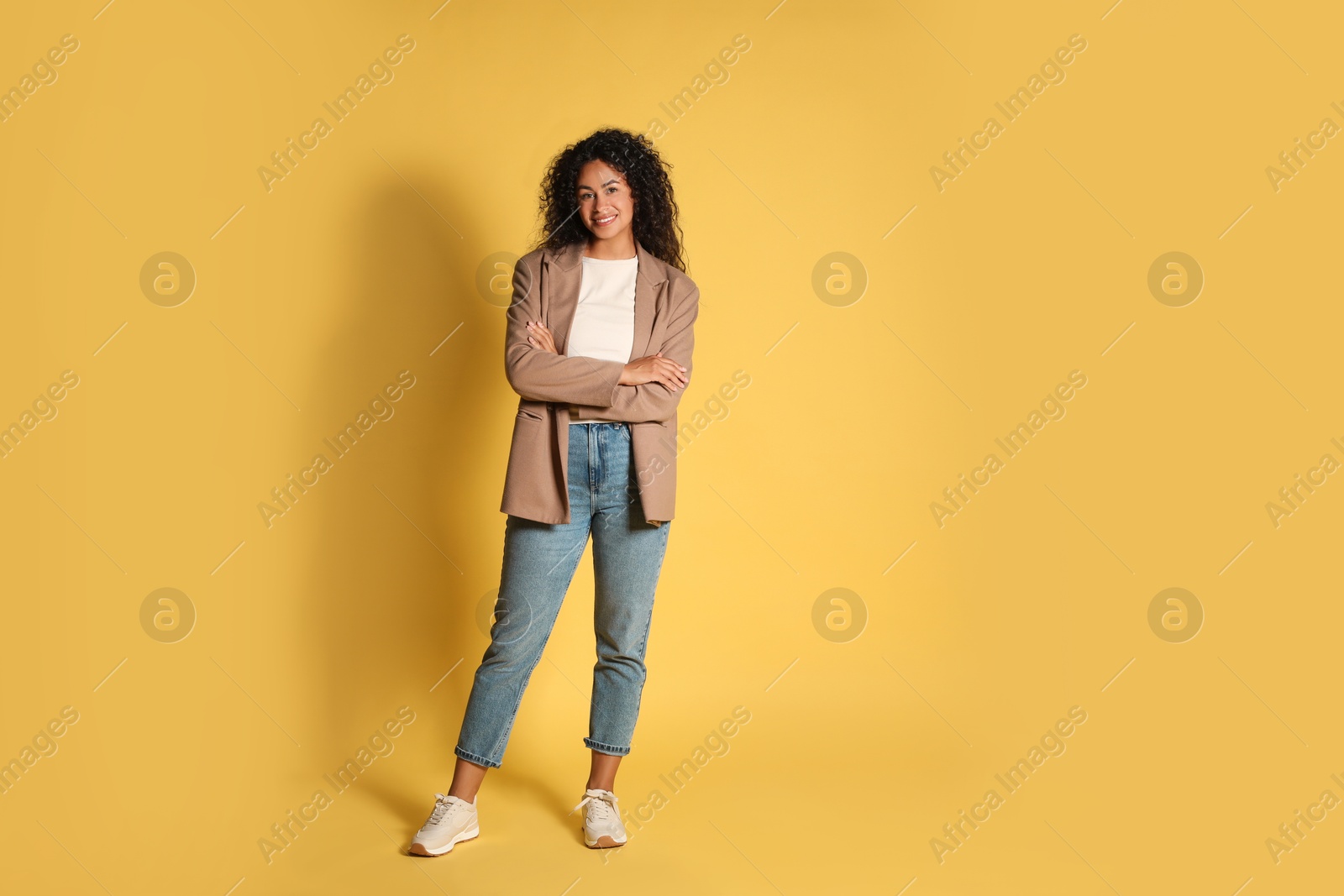 Photo of Beautiful woman in stylish jacket on yellow background