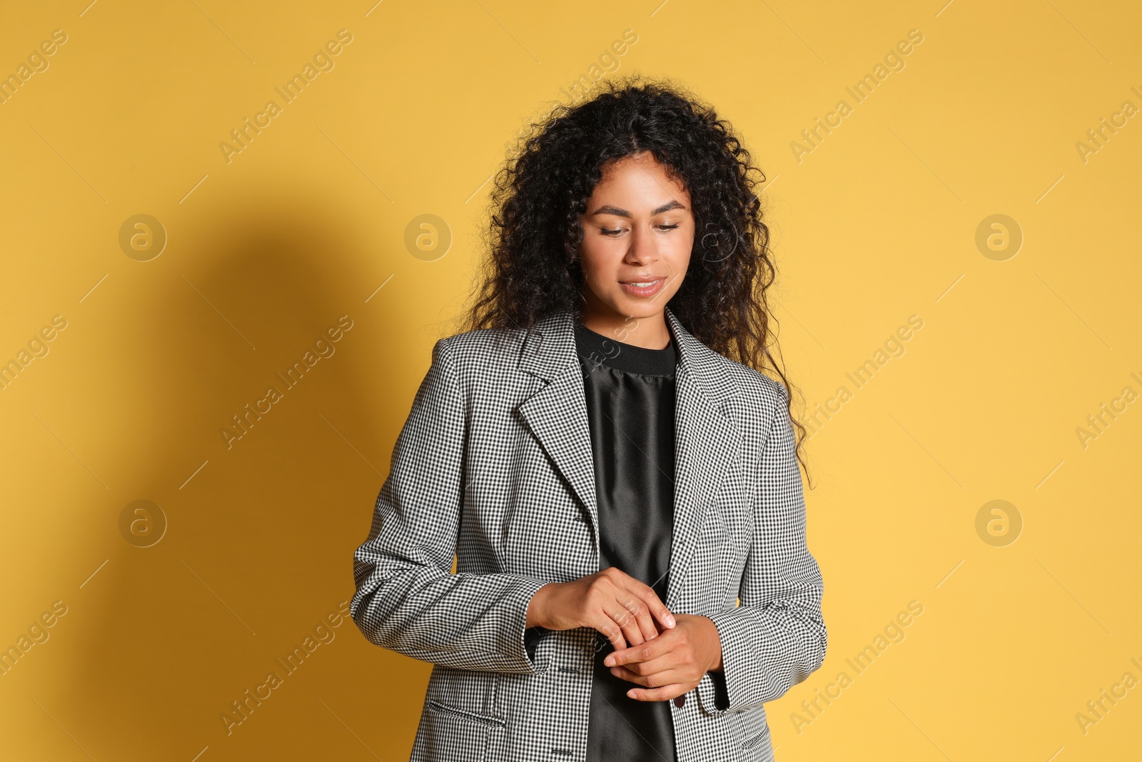 Photo of Beautiful woman in stylish jacket on yellow background