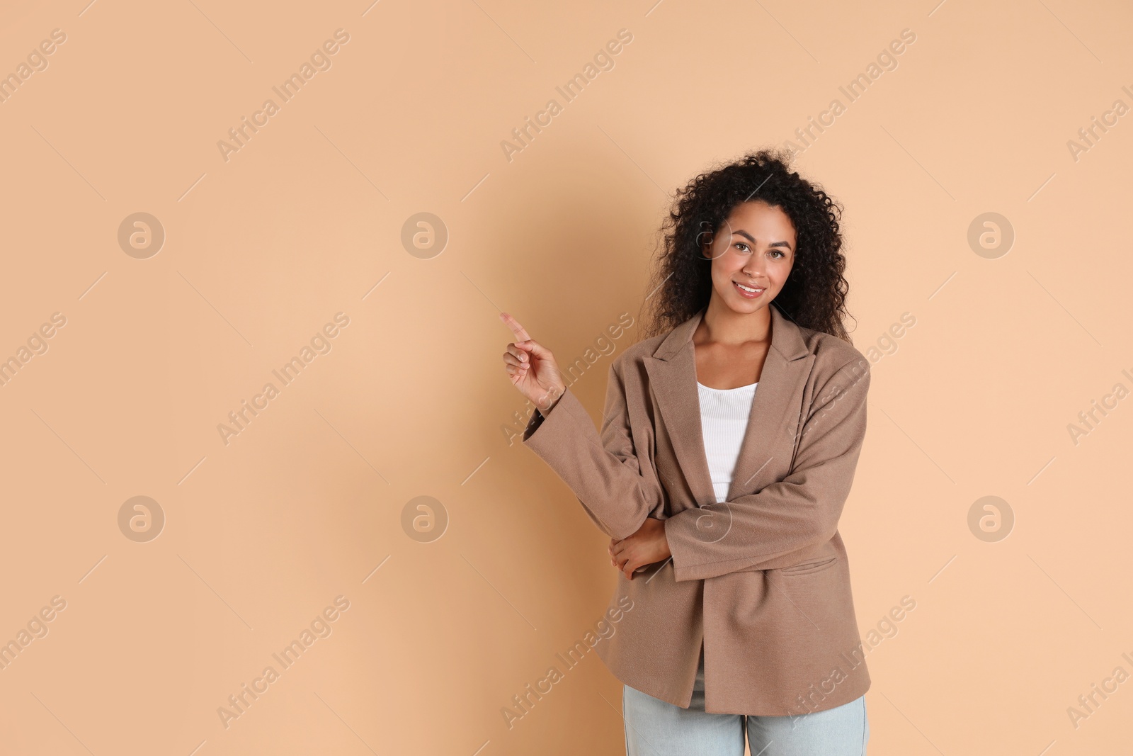 Photo of Beautiful woman in stylish jacket on beige background, space for text