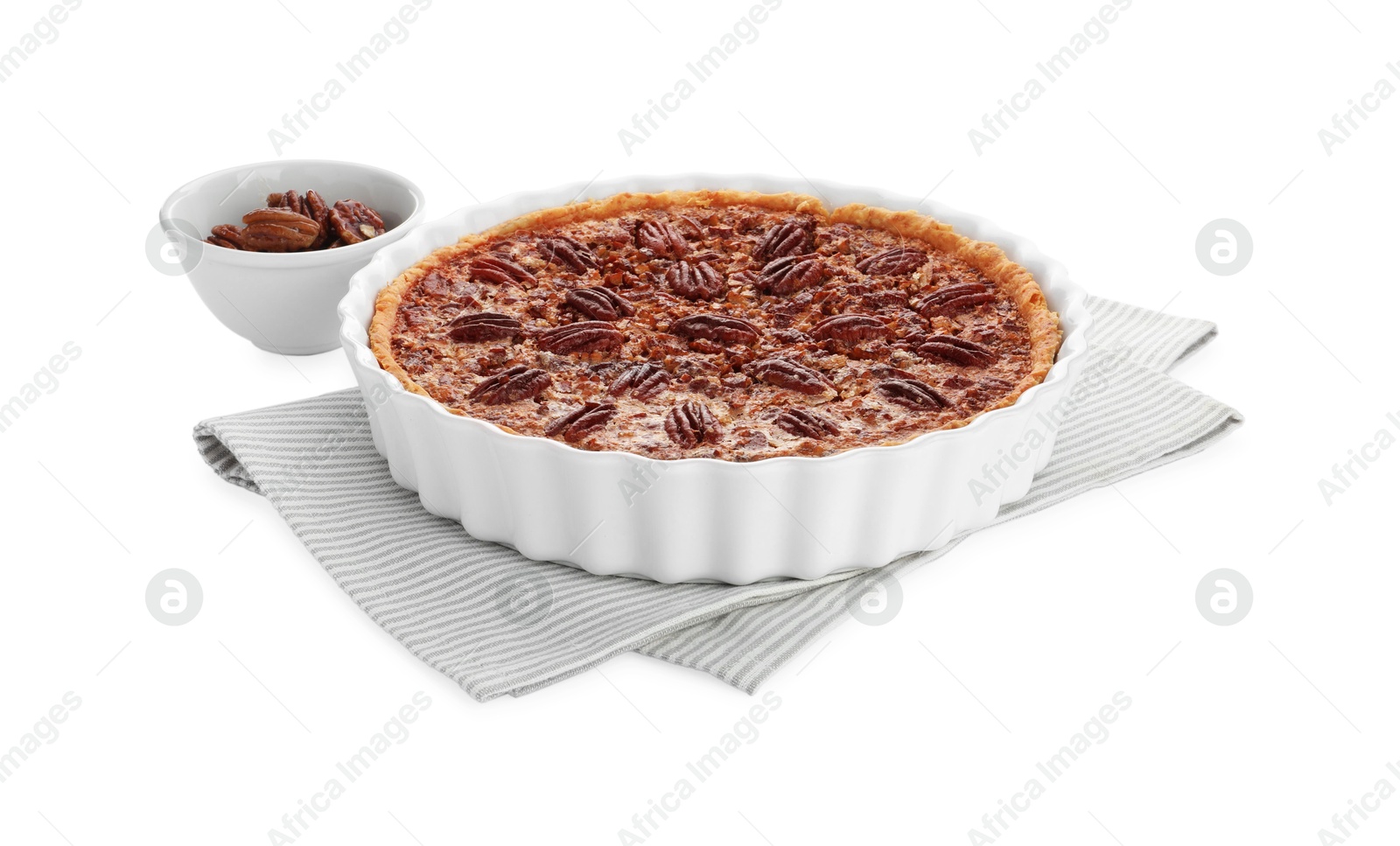 Photo of Delicious pecan pie in baking dish and bowl with fresh nuts isolated on white