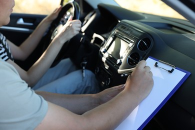 Driving school. Student passing driving test with examiner in car, closeup