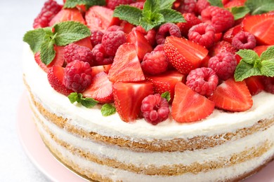 Photo of Tasty sponge cake with fresh berries and mint on table, closeup