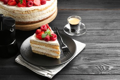 Photo of Tasty sponge cake with fresh berries and mint served on black wooden table, space for text