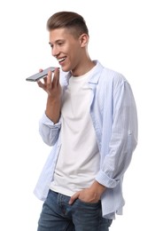 Young man recording voice message via smartphone on white background