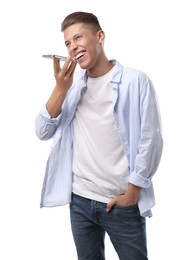 Young man recording voice message via smartphone on white background