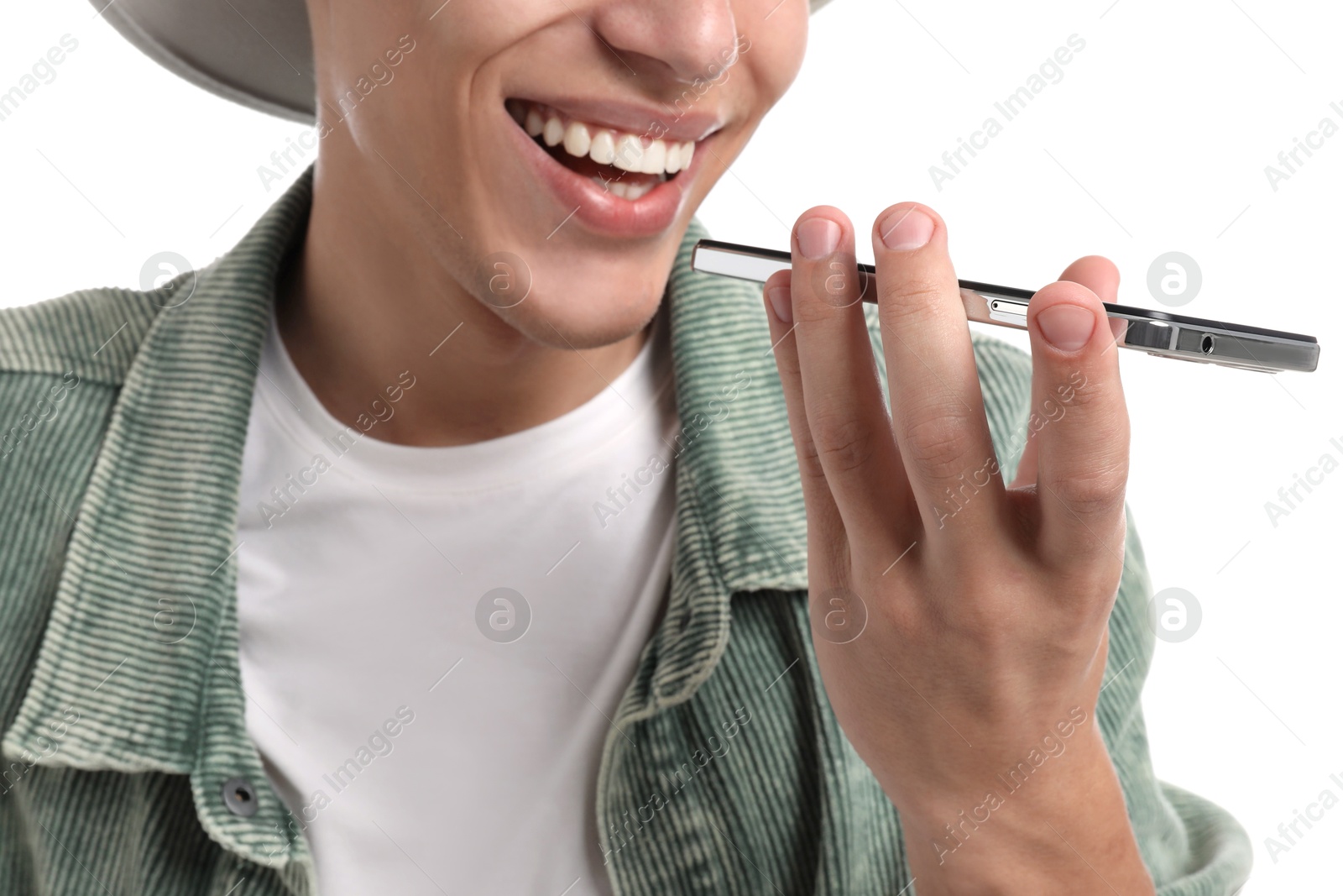 Photo of Young man recording voice message via smartphone on white background, closeup