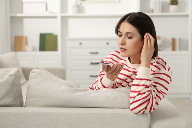 Photo of Beautiful woman recording voice message via smartphone at home