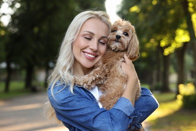 Beautiful young woman with cute dog in park