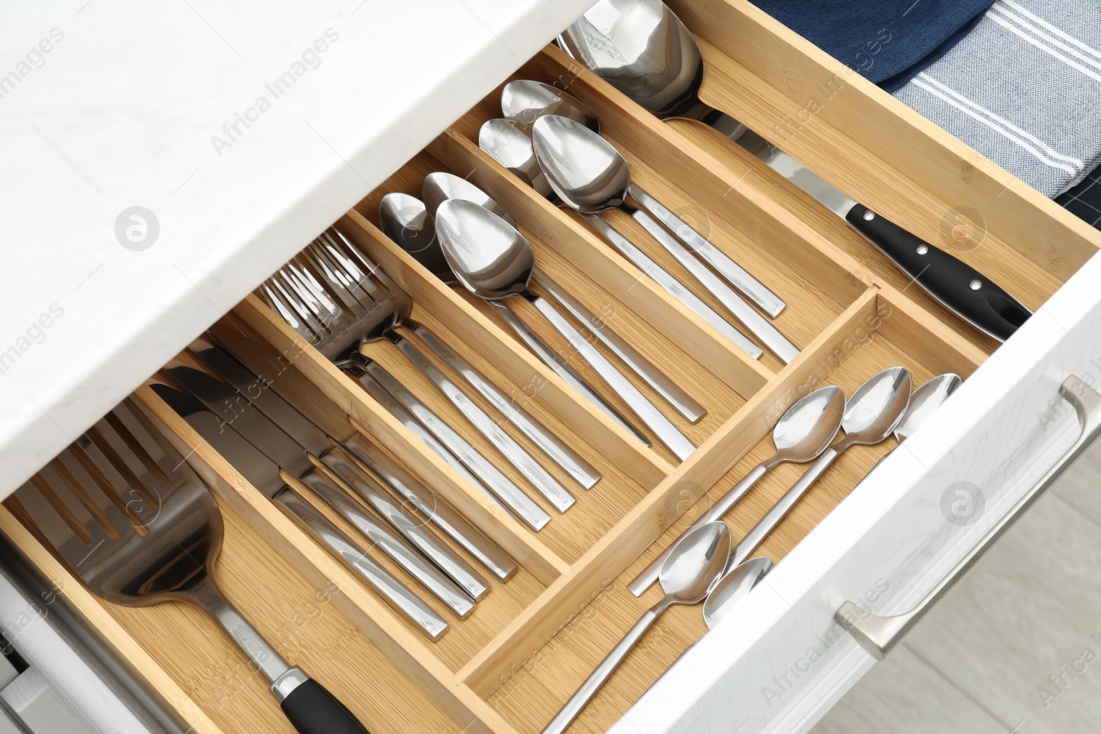 Photo of Box with cutlery in drawer, closeup. Kitchen utensils storage