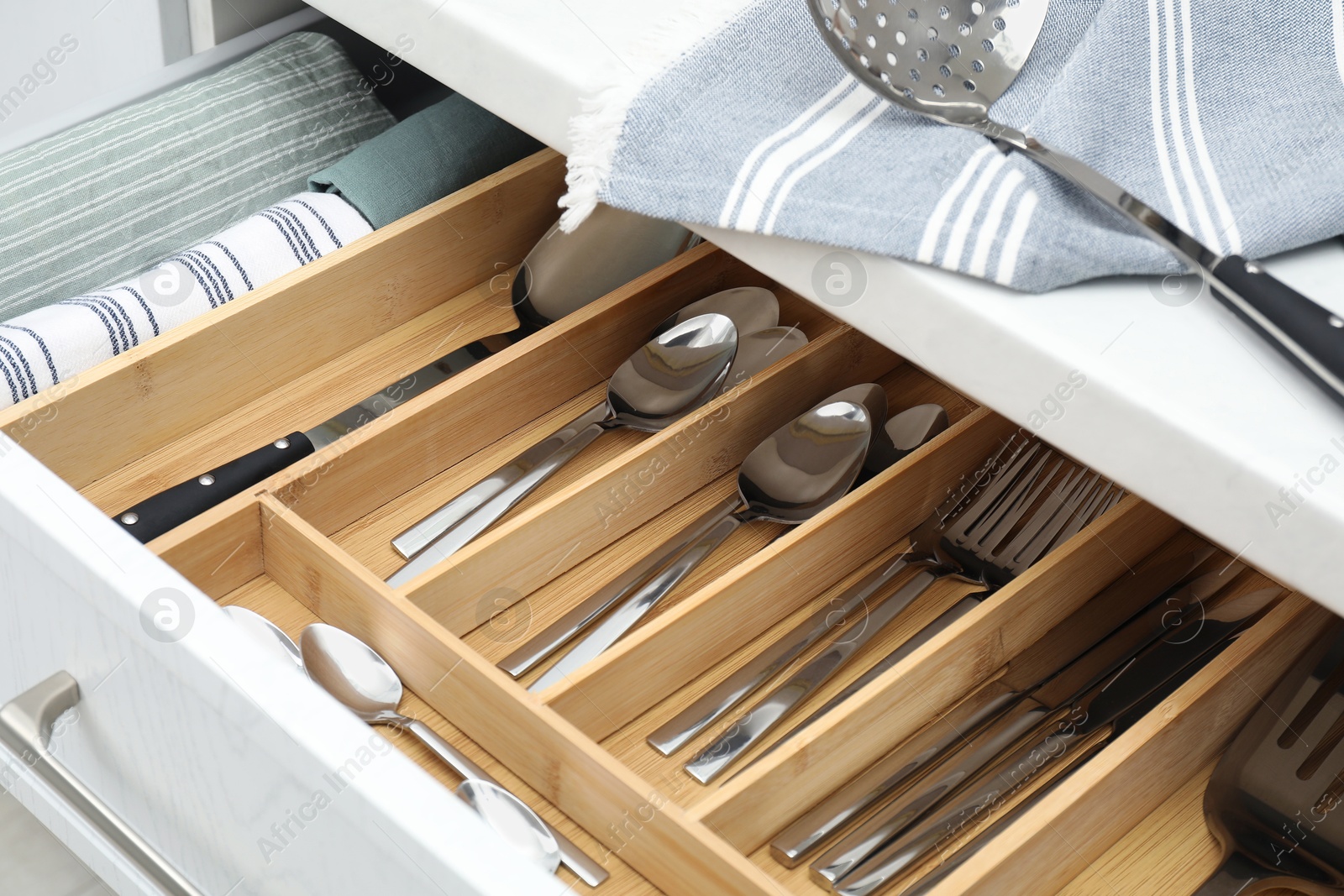 Photo of Box with cutlery in drawer, closeup. Kitchen utensils storage