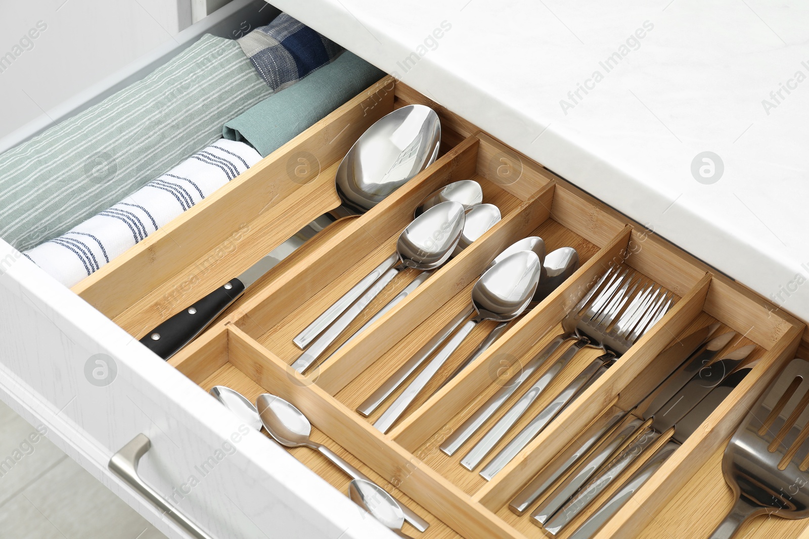 Photo of Box with cutlery in drawer, closeup. Kitchen utensils storage