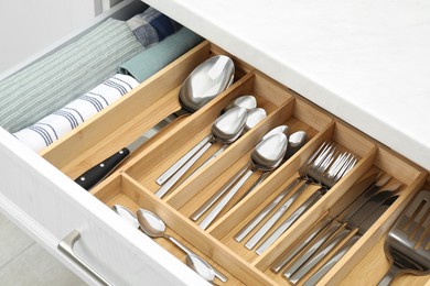 Photo of Box with cutlery in drawer, closeup. Kitchen utensils storage