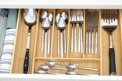 Photo of Box with cutlery in drawer, above view. Kitchen utensils storage