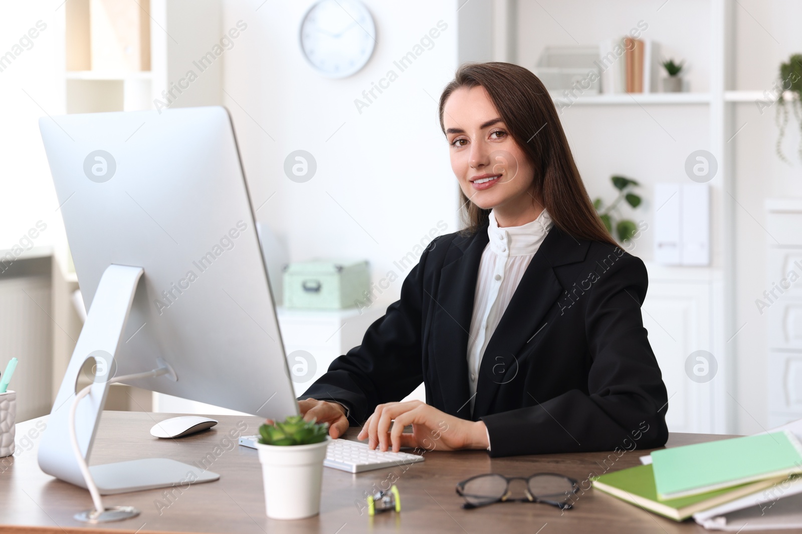 Photo of Portrait of smiling businesswoman at table in office