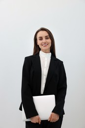 Photo of Portrait of smiling businesswoman with laptop on white background