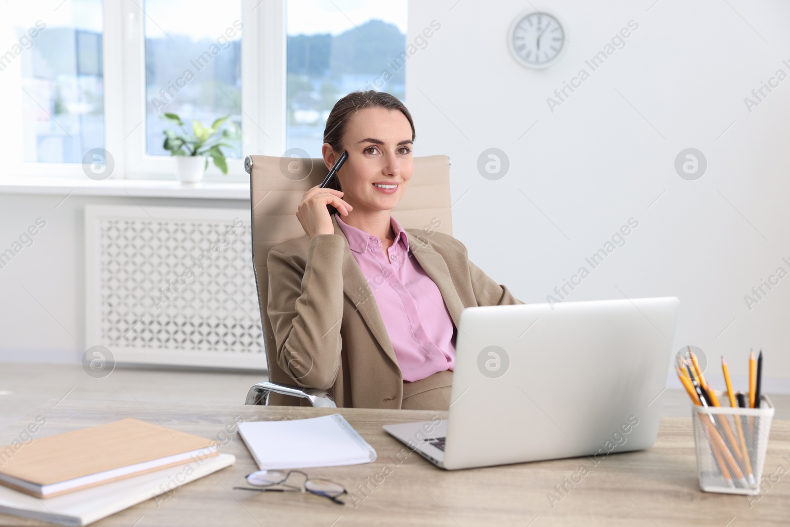 Photo of Smiling businesswoman working at table in office