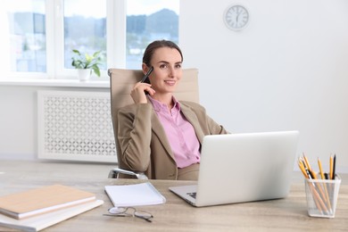 Smiling businesswoman working at table in office