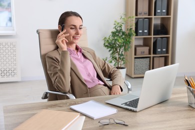 Smiling businesswoman working at table in office