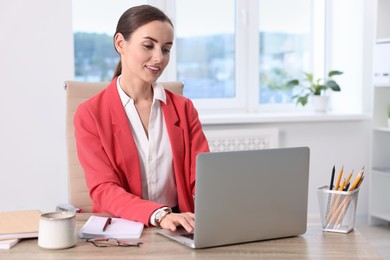 Photo of Smiling businesswoman working at table in office