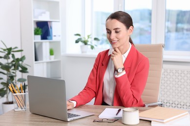 Smiling businesswoman working at table in office