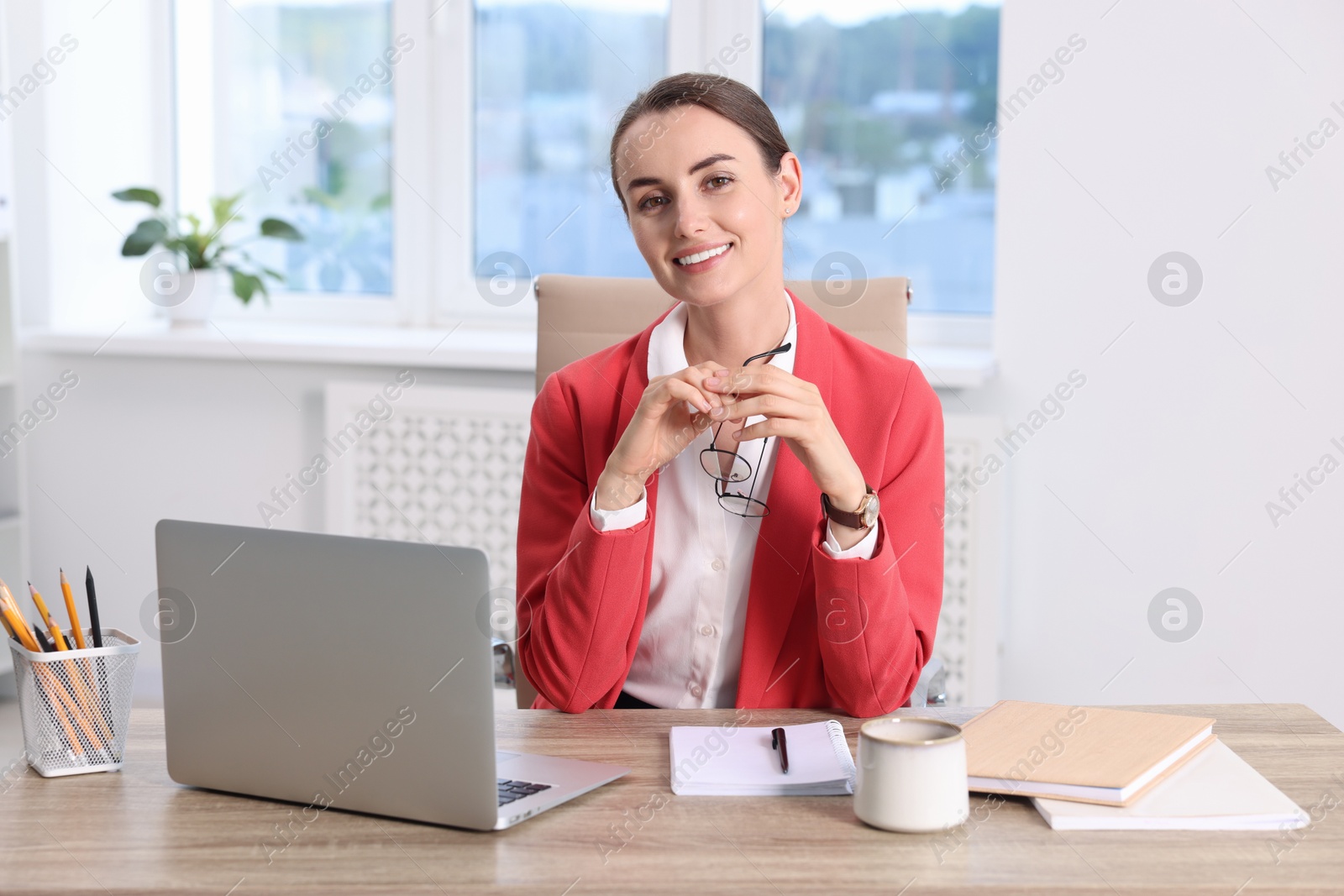 Photo of Portrait of smiling businesswoman at table in office