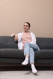 Smiling woman relaxing on sofa at home