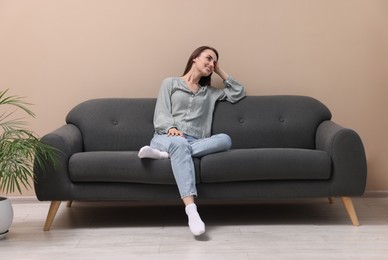 Smiling woman relaxing on sofa at home