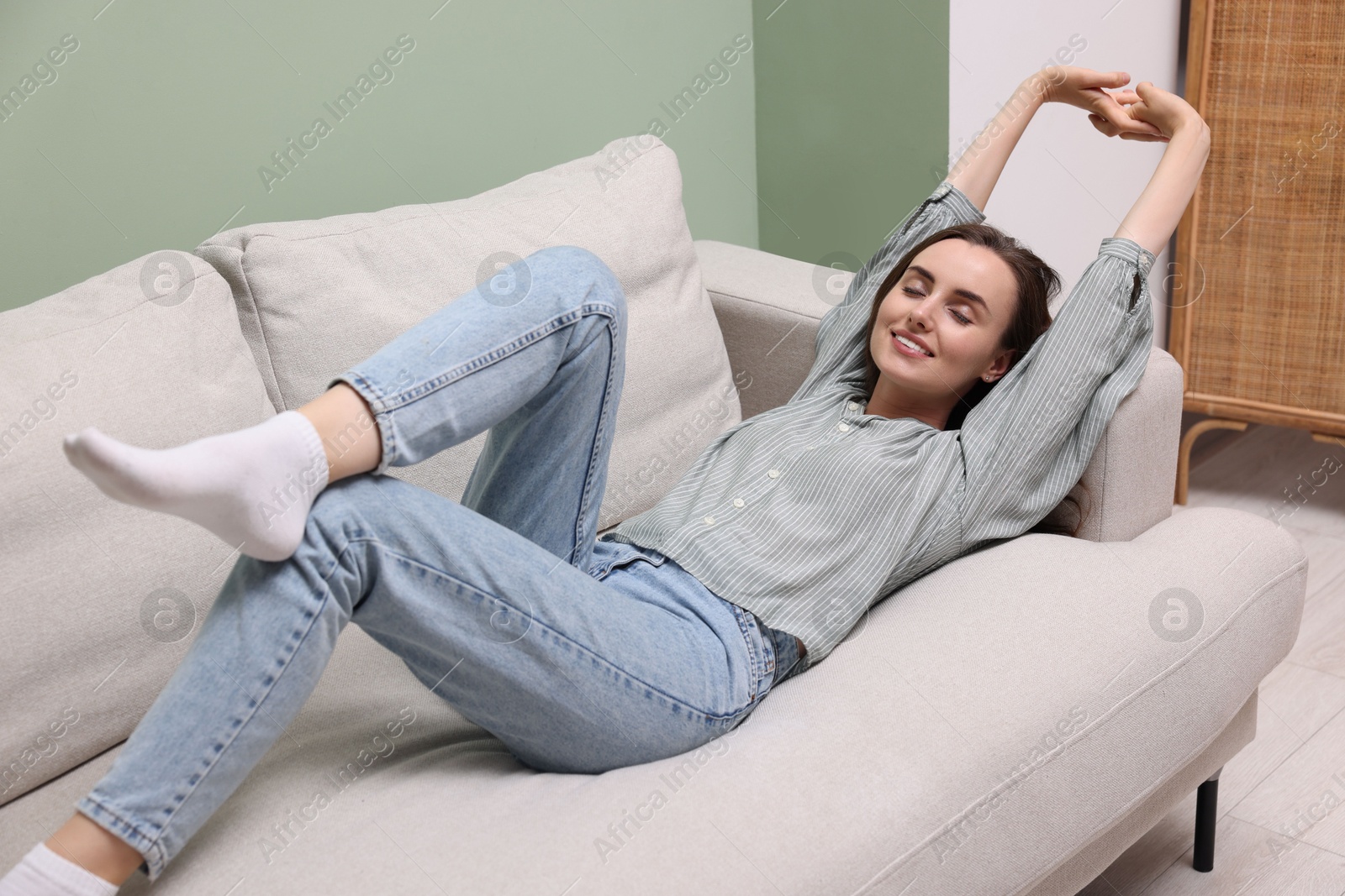 Photo of Smiling woman relaxing on sofa at home