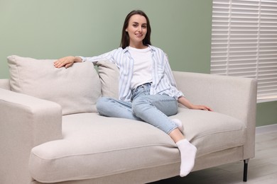 Photo of Smiling woman relaxing on sofa at home