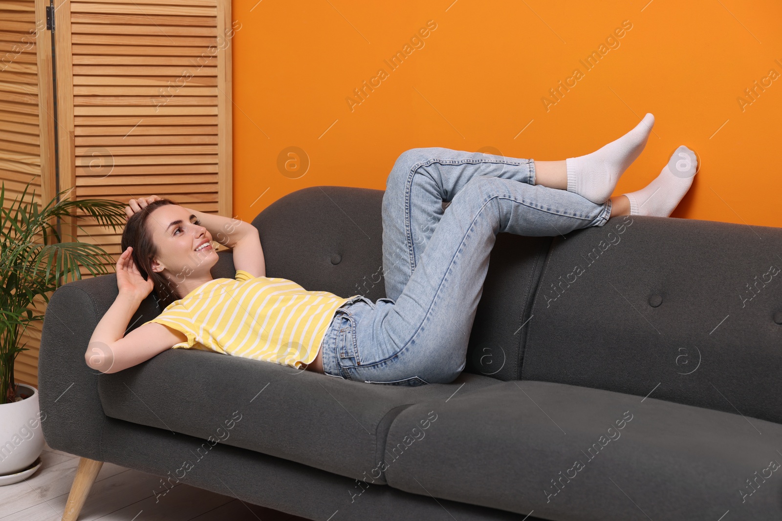 Photo of Smiling woman relaxing on sofa at home