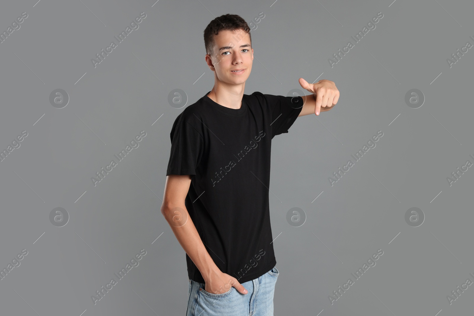 Photo of Teenage boy wearing black t-shirt on grey background