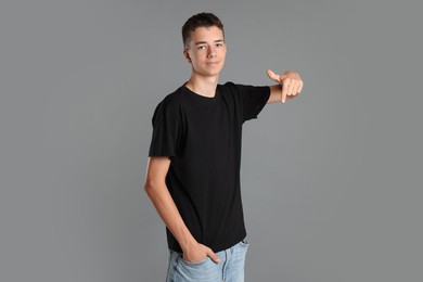 Teenage boy wearing black t-shirt on grey background