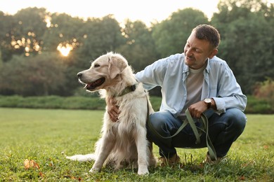 Photo of Smiling man with cute Golden Retriever dog on spring day