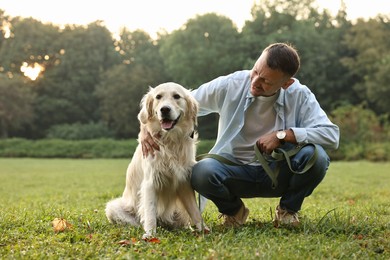 Smiling man with cute Golden Retriever dog on spring day