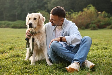 Smiling man with cute Golden Retriever dog on spring day