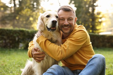 Photo of Smiling man with cute Golden Retriever dog on spring day