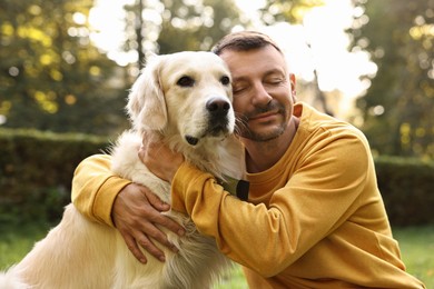 Photo of Man with cute Golden Retriever dog on spring day