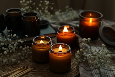 Burning candles and beautiful flowers on table