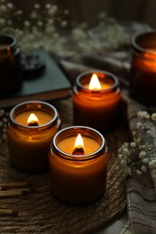 Burning candles and beautiful flowers on table