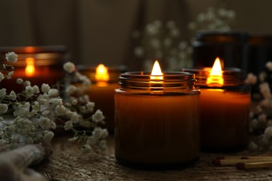 Photo of Burning candles and beautiful flowers on table