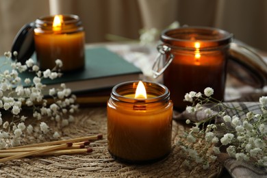 Burning candles and beautiful flowers on table